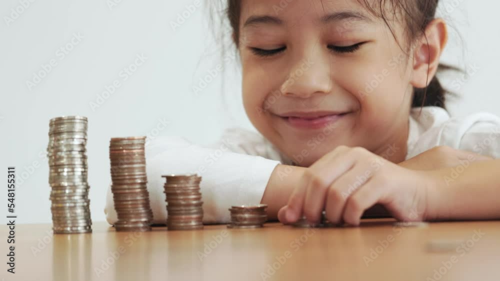 Closed up coin towers with adorable asian girl who is saving her money for future finance shows concept of financial and economic planning strategy for child or family which is the success of wealthy. Closed up coin towers with adorable asian girl who is saving her money for future finance shows concept of financial and economic planning strategy for child or family which is the success of wealthy.