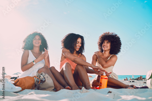 Friends, sunscreen and relax at beach, happy and summer holiday, travel and blue sky in Miami, happy and smile. Blaxk women, vacation and ocean vacation, happiness and afro with skincare and safety © C Haas/peopleimages.com