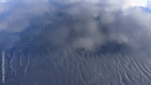 Top down shot of mud waves in black sand of Icelandic beach during cloudy day photo