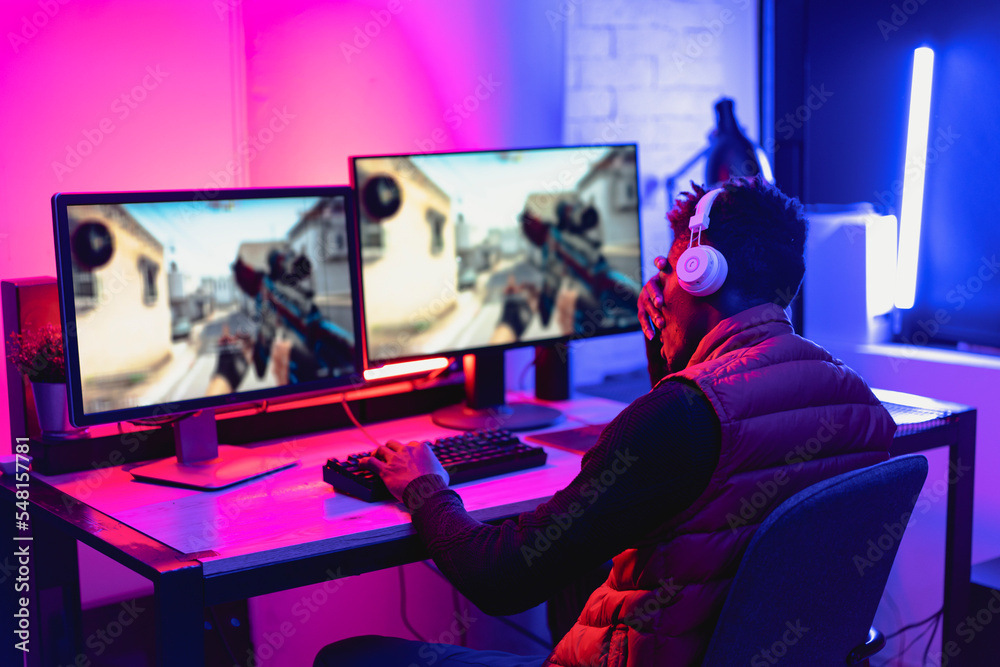 Young African man playing video game on computer. Streamer guy sitting at home and plays another match. Young African man playing video game on computer. Streamer guy sitting at home and plays another match.