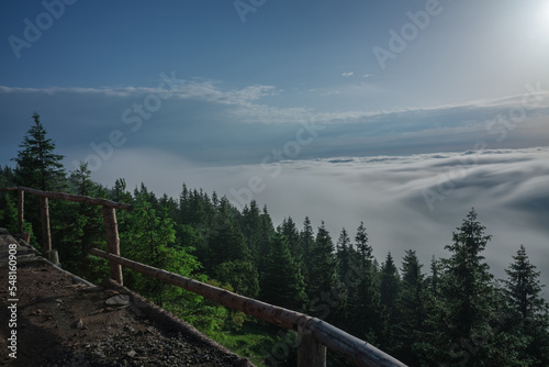 View from Serak in Jeseniky mountains on a summer foggy morning and sea of clouds around mountain peak