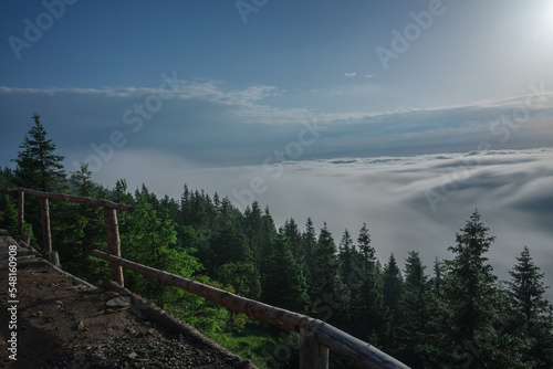 View from  Serak in Jeseniky mountains on a summer foggy morning and  sea of clouds around mountain peak photo