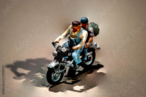 Miniature men going for a trip on a motorcycle