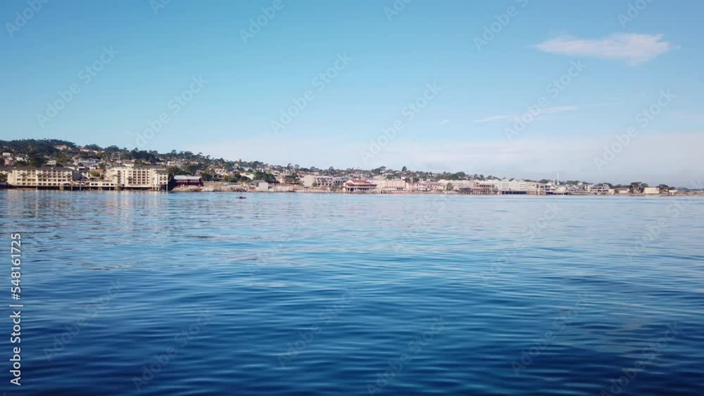 Gimbal wide shot of Cannery Row from a moving boat on the ocean off the coast of Monterey, California. 4K Gimbal wide shot of Cannery Row from a moving boat on the ocean off the coast of Monterey, California. 4K