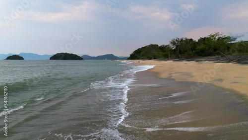 flying close to the waves on the beach sand - Ubatuba, Brazil photo