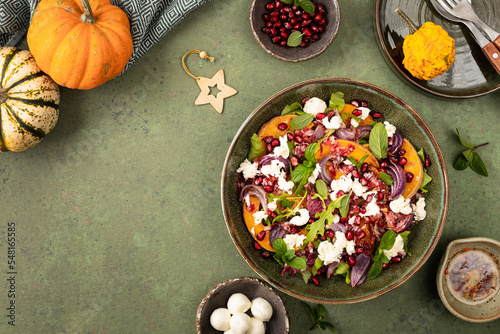 Warm winter quinoa salad with pumpkin, chorizo and mozzarella, arugula leaves and pomegranate.