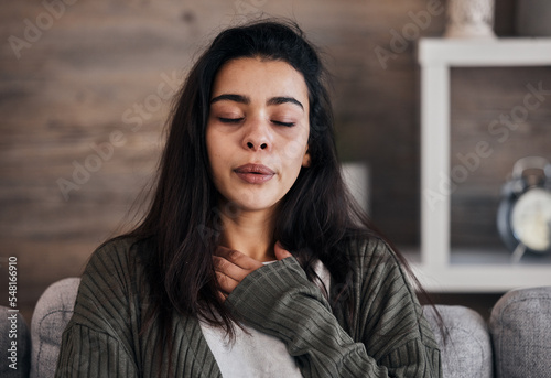 Depression, sad and woman with eyes closed in home thinking of problems. Anxiety, mental health and unhappy, depressed and lonely female on sofa in living room trying to calm down and relax in house. photo