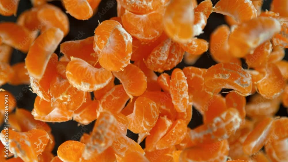 Super Slow Motion Shot of Peeled Tangerines Flying Towards Camera on Black Background at 1000fps.