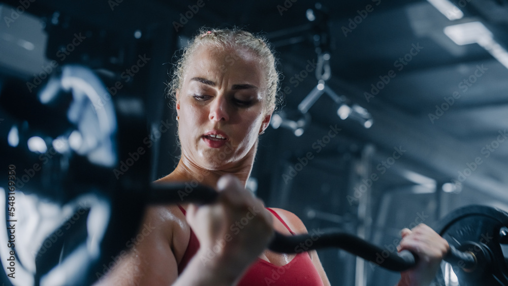 Portrait of an Uncompromising Young Woman Training with Heavy Barbell Exercise in a Dark Gym. A Defying Female Bodybuilder Proving Her Strength With Extreme Workout. She is Focused on her Improvement Portrait of an Uncompromising Young Woman Training with Heavy Barbell Exercise in a Dark Gym. A Defying Female Bodybuilder Proving Her Strength With Extreme Workout. She is Focused on her Improvement