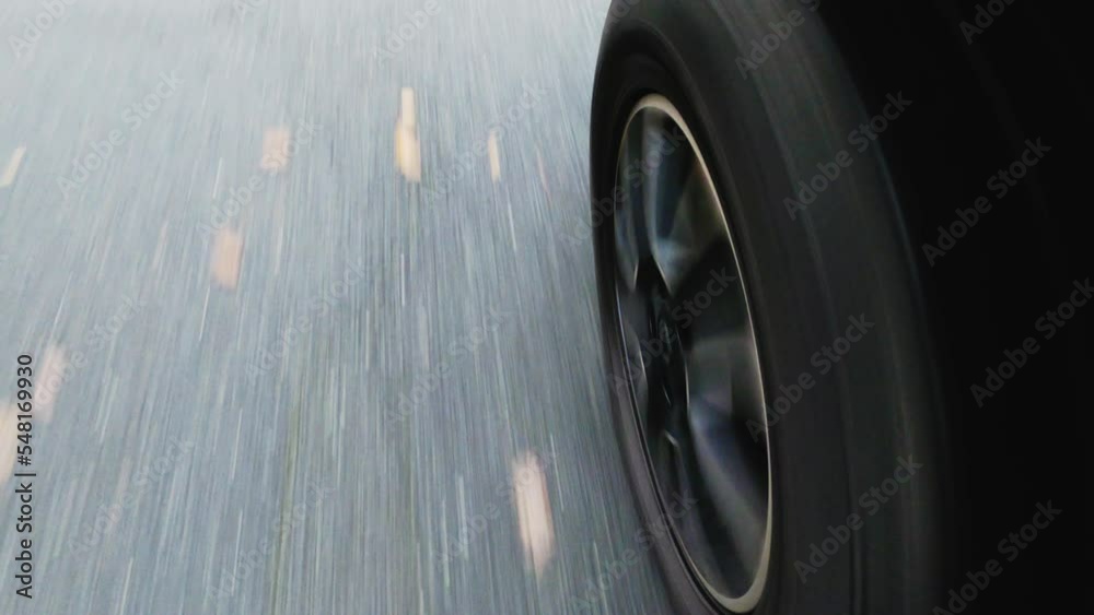 Dynamic closeup view with motion blur of the fast spinning tire on the