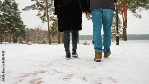 Close-up of a woman and a man walking. Walk on the snowy path.