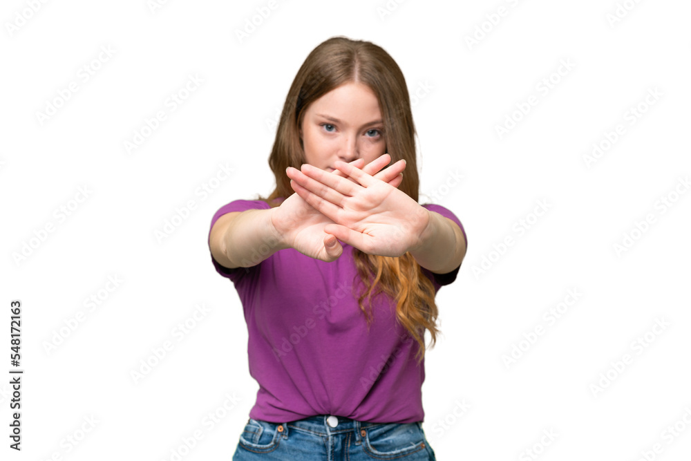 Young pretty woman over isolated background making stop gesture with her hand to stop an act Young pretty woman over isolated background making stop gesture with her hand to stop an act
