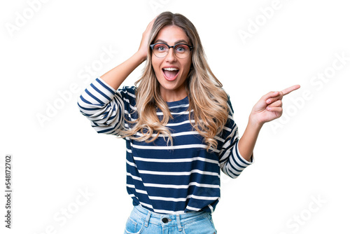 Fototapeta Young Uruguayan woman over isolated background surprised and pointing finger to