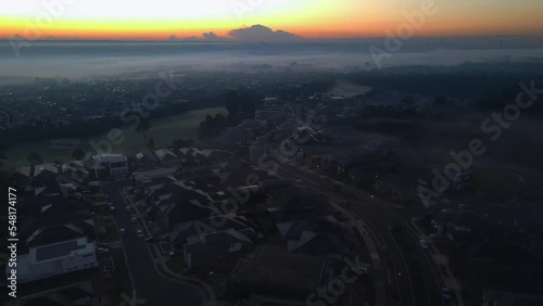 Drone shot of residential in rural area with cloud background and orange sky photo