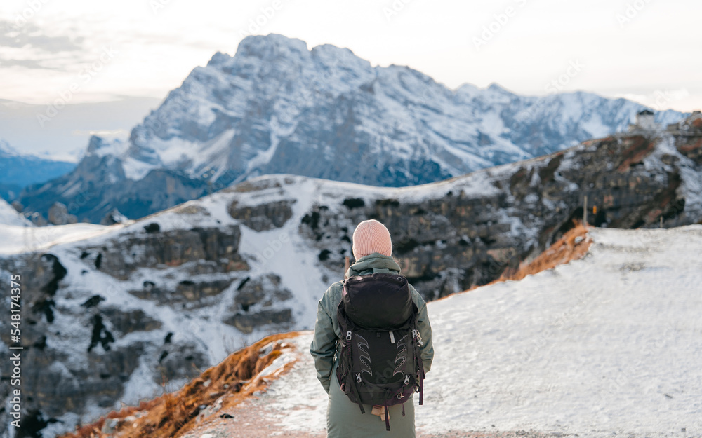 Young girl enjoying beauty of nature looking at mountain in Dolomites. Adventure travel in Italy, Europe. Travel and dream vacation concept. High rocks, winter landscape Young girl enjoying beauty of nature looking at mountain in Dolomites. Adventure travel in Italy, Europe. Travel and dream vacation concept. High rocks, winter landscape