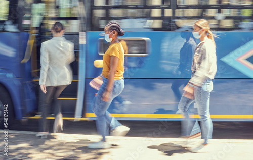 Women, covid travel and bus stop in city morning commute, public transportation or local travelling in motion blur. Diversity, passenger and covid 19 face mask in vehicle healthcare safety compliance