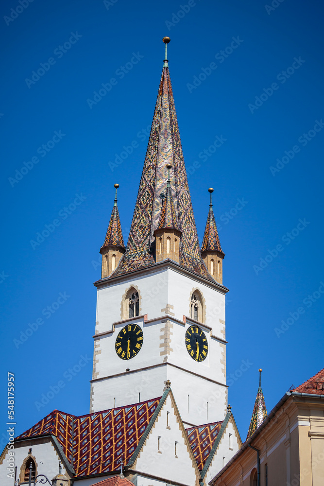 Detailed view of the Sibiu Lutheran cathedral tower. Gothic architectural cathedral with colourful tiles.