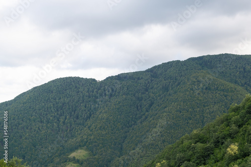 Mountain peak blue sky white and gray clouds, view of smoky forest mountain peak  © Ensar