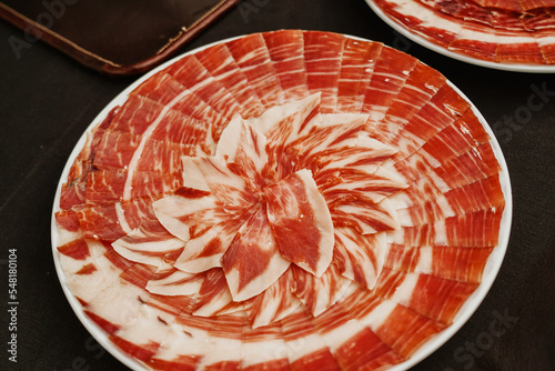 Plate with Iberian cut ham. Spanish jamon iberico (ham). Selective focus point