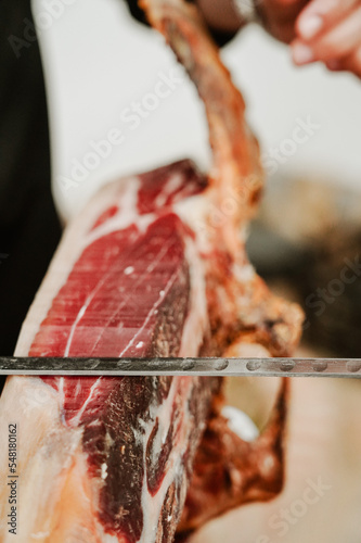 Profesional slicing Spanish jamon iberico (ham). Selective focus point