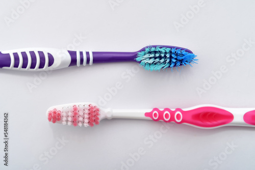 Old and new toothbrush isolated on the pale blue background. Compared before and after using. Dental concept. Close-up.