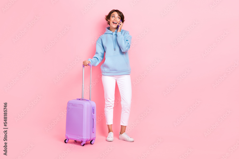 Photo of attractive lady speak telephone enjoy 4g fast speed connection hold suitcase look empty space isolated on pink color background Photo of attractive lady speak telephone enjoy 4g fast speed connection hold suitcase look empty space isolated on pink color background