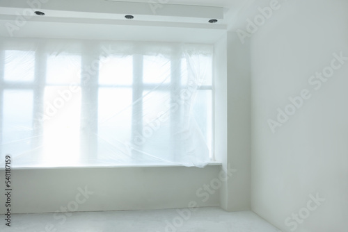 Big windows covered with plastic film indoors