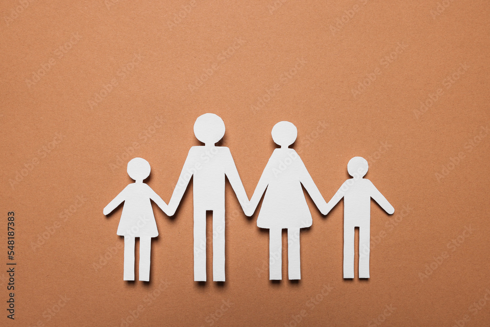 Paper family figures on brown background, top view. Insurance concept Paper family figures on brown background, top view. Insurance concept