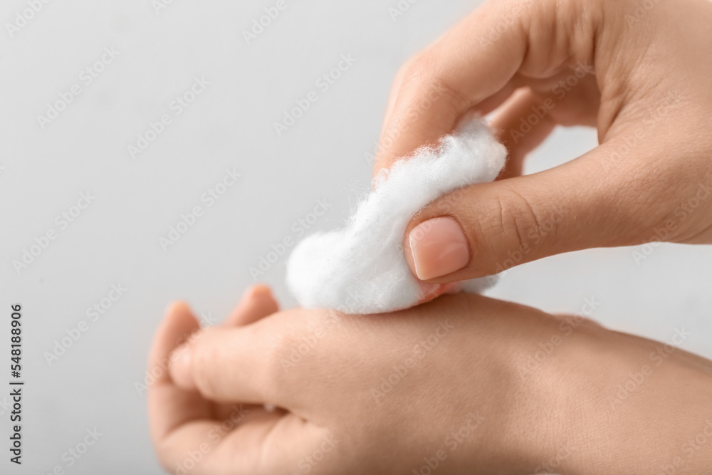 Woman with cotton wool on light background, closeup Woman with cotton wool on light background, closeup