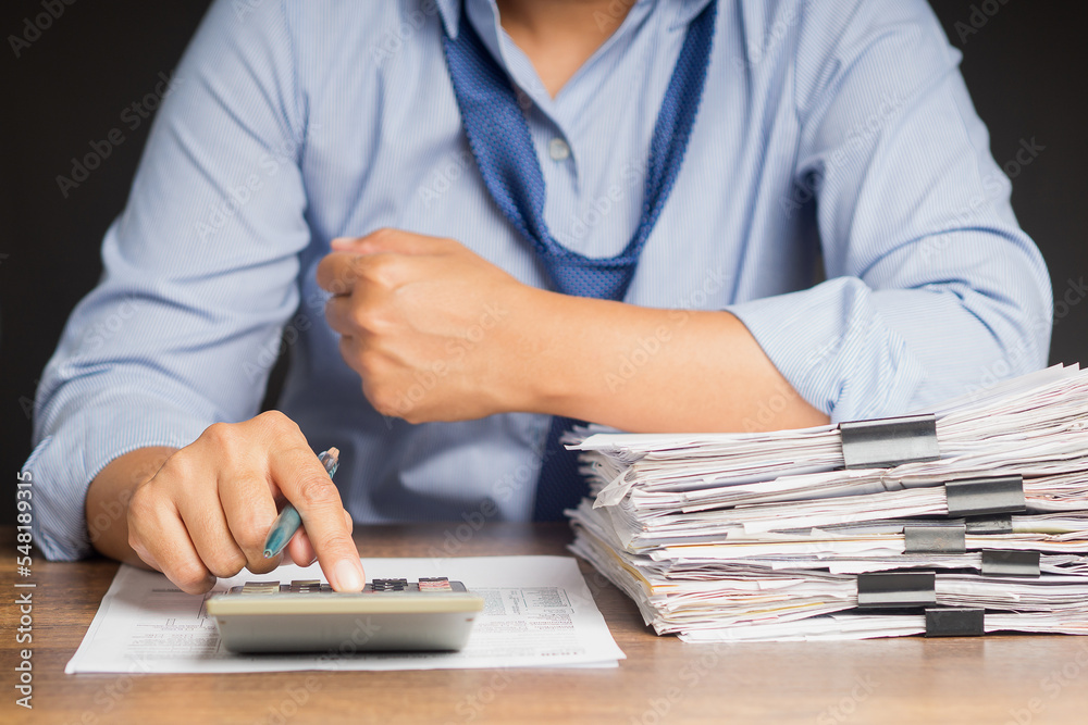 Fototapeta premium Tax day concept. An individual income tax payment form online. Close-up of the hand using a calculator to calculate taxes while sitting in the office