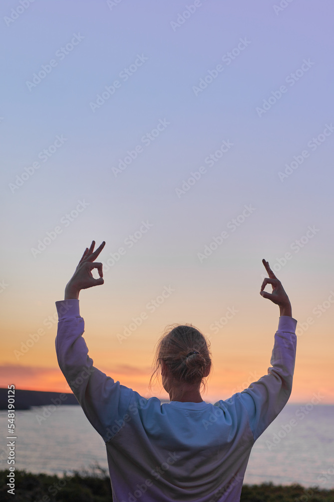 woman performing a classic yoga pose at sunset outdoors with large copy space in portrait format for advertising woman performing a classic yoga pose at sunset outdoors with large copy space in portrait format for advertising
