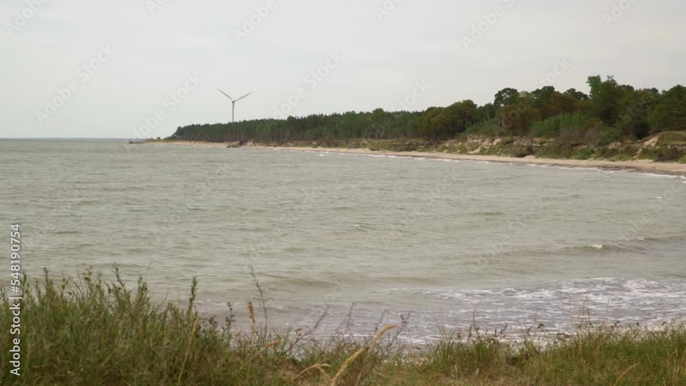 Windmill on the sea shore of a sea producing energy. Green power generation