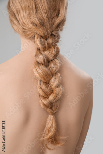 Canvastavla Young woman with pigtail hairstyle on light background