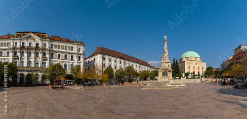 view of the Szechenyi Square in downtown Pécs with the Holy Trinity Statue and the Pasha Qasim Mosque photo