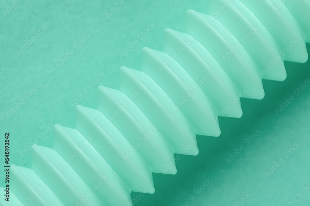 Fototapeta premium Closeup view of corrugated tubing on mint background