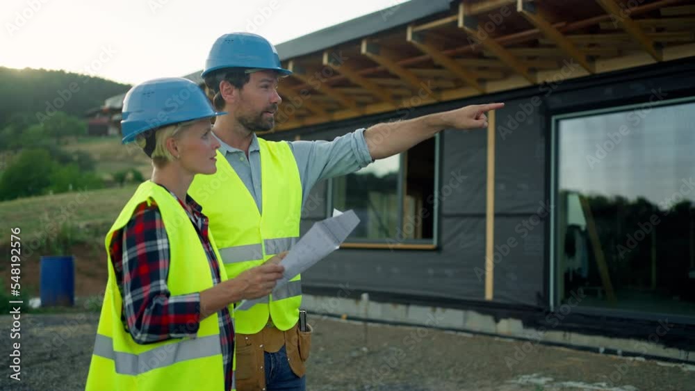 Female architect and male worker consulting plans on building site. Female architect and male worker consulting plans on building site.