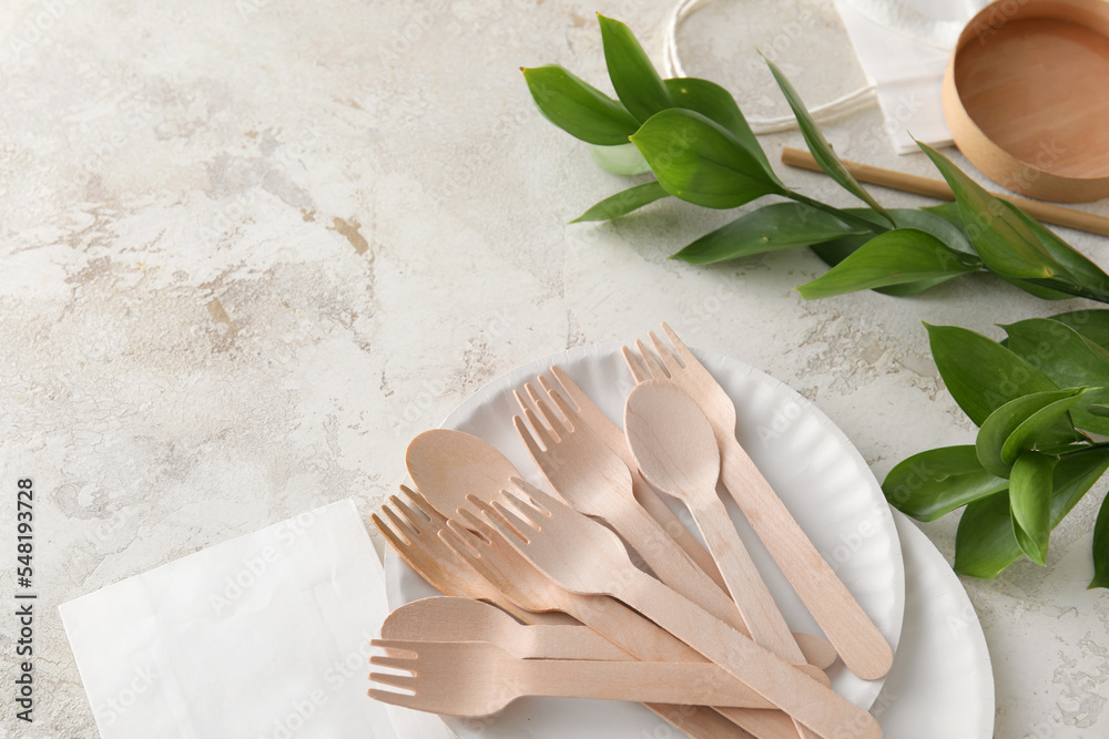 Eco tableware and plant branch on light background Eco tableware and plant branch on light background