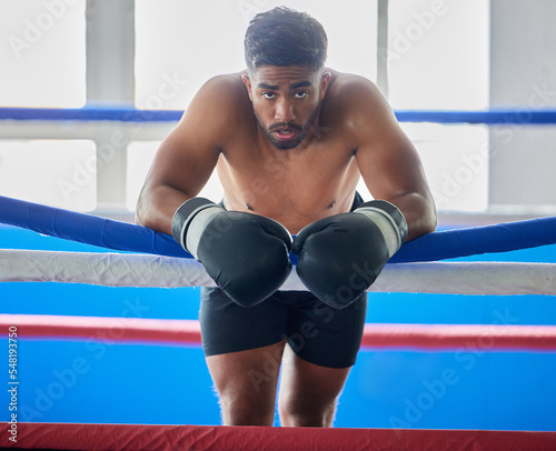 Boxing ring, man and tired from fight, training and workout in gym exercise, burnout and fail in competition games. Portrait sweating boxer, athlete and guy, break and breathing in sports arena club