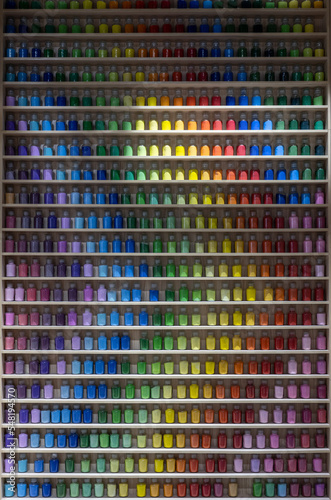 Colorful paint bottles on wooden shelves