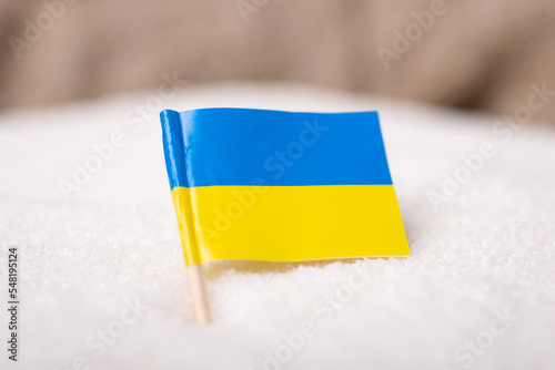 Flag of Ukraine in sack of sugar. Concept of ukrainian sugar, export, import of product photo