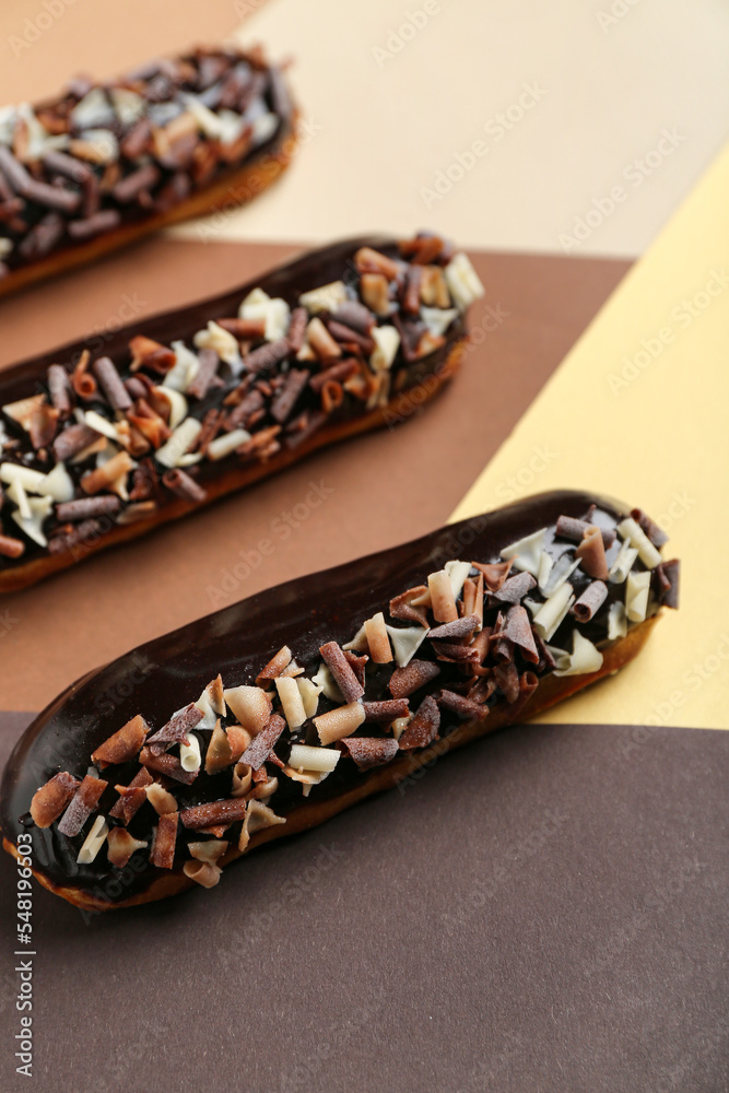 Delicious chocolate eclairs on color background, closeup - obrazy, fototapety, plakaty 