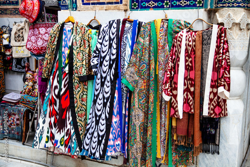 Uzbek traditional clothes such as robes and other colorful souvenirs, Tashkent, Uzbekistan. 