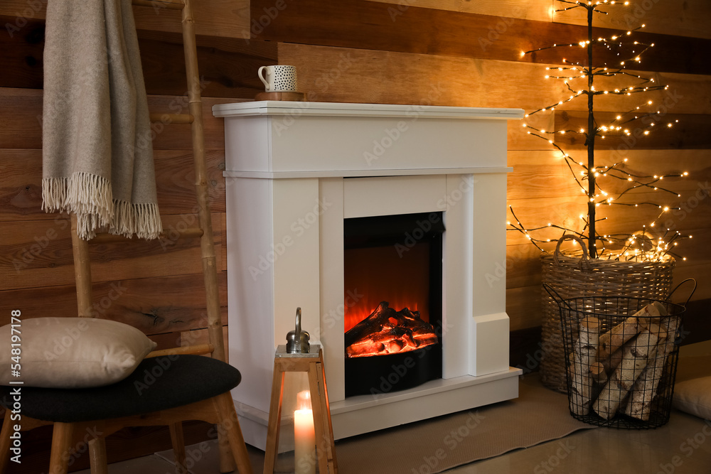 Fototapeta premium Interior of dark living room with fireplace and glowing tree lamp