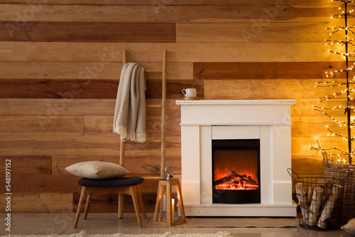 Interior of living room with fireplace and glowing tree lamp