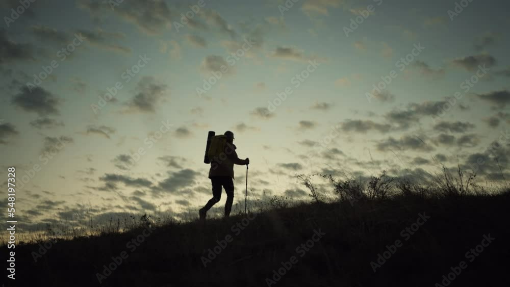 Man walking up a hill at sunrise. Man walking up a hill at sunrise.