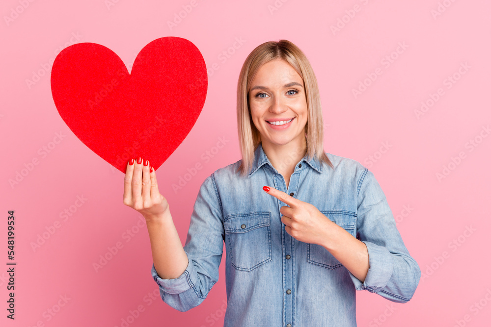 Photo of lovely cheerful girl holding in hands point heart form isolated over pastel color background Photo of lovely cheerful girl holding in hands point heart form isolated over pastel color background