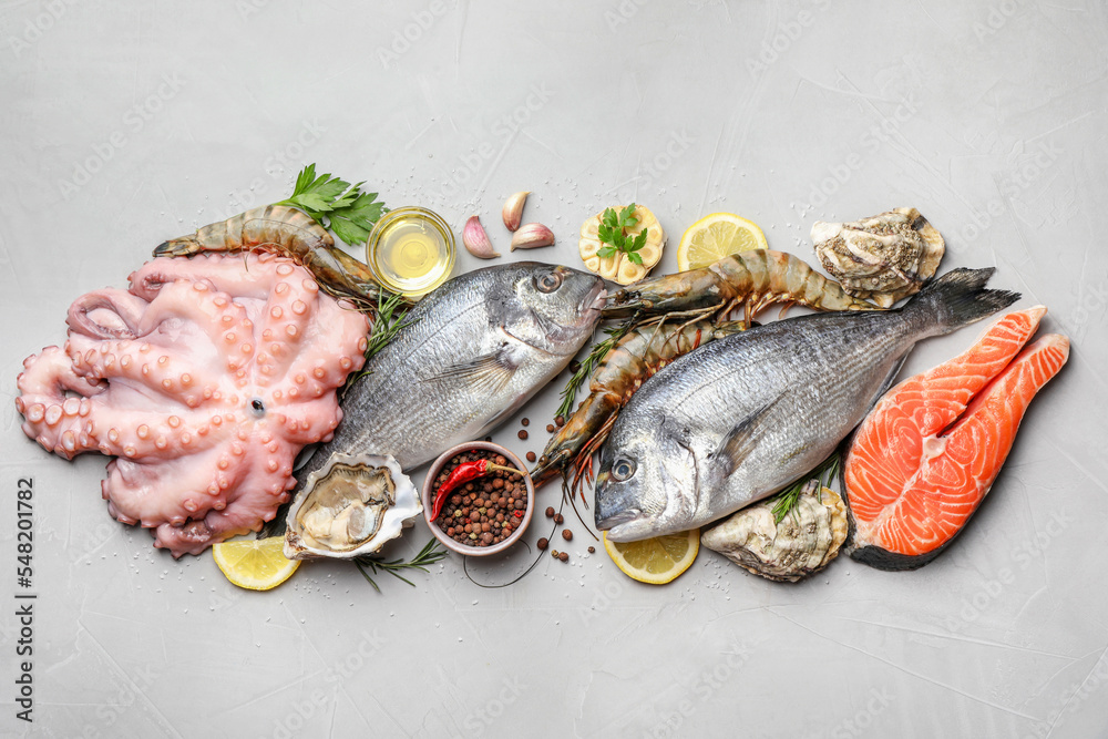 Fototapeta premium Flat lay composition with fresh raw dorado fish and different seafood on light grey table