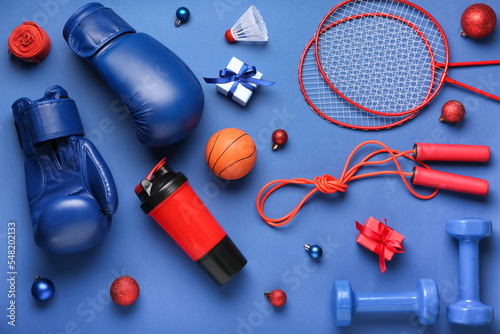 Fototapeta Naklejka Na Ścianę i Meble -  Sports equipment with Christmas balls and gifts on blue background