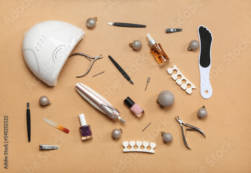 Manicure tools with Christmas balls on beige background