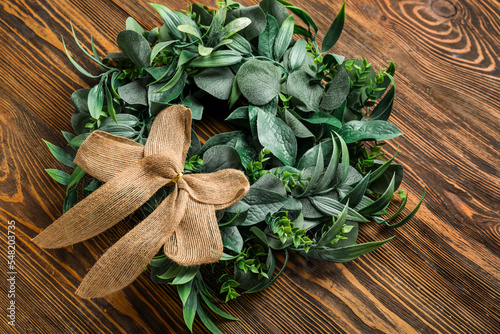 Stylish Christmas wreath on wooden background, closeup